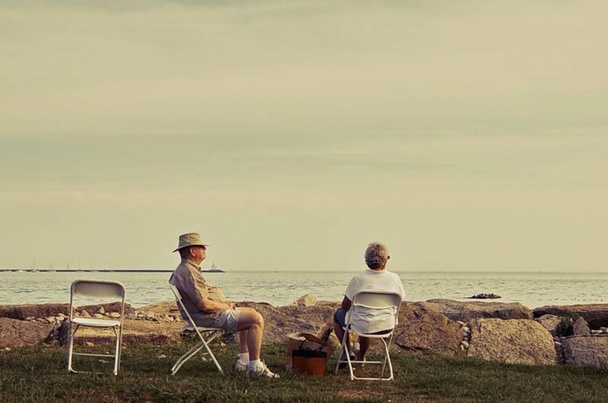 An old man and women rest at the ocean beach, retirement benefits - Фото, изображение
