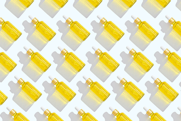 trendy pattern of dropper bottles with white pipette and yellow liquid on white background - Fotoğraf, Görsel