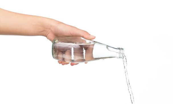 рука держа бутылку наливая брызги воды изолированы на белом фоне
 - Фото, изображение