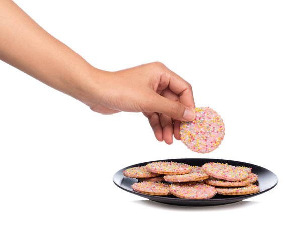 main tenant des biscuits aux fraises avec garniture saupoudrer sur un plat isolé sur fond blanc
. - Photo, image