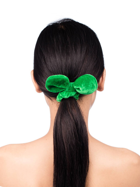 Porträt einer jungen Frau mit grüner Schleife im Haar isoliert auf weißem Hintergrund. - Foto, Bild