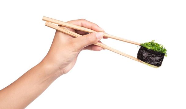 Sushi de mano con palillos aislados sobre fondo blanco
 - Foto, Imagen