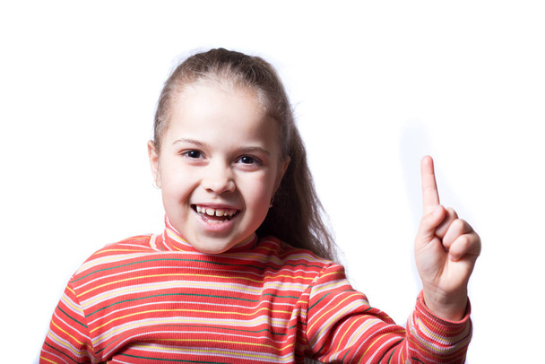 Das kleine Mädchen hat ein weiteres Ziel erreicht. niedliches Mädchen zeigt Zeigefinger auf weißem Hintergrund. - Foto, Bild