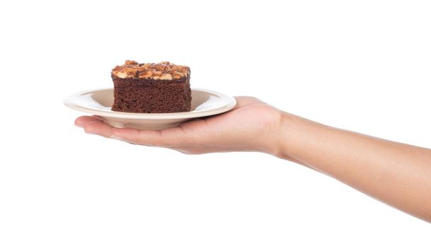 χέρι εκμετάλλευση αμυγδάλου Brownie σε πιάτο που απομονώνονται σε λευκό φόντο - Φωτογραφία, εικόνα