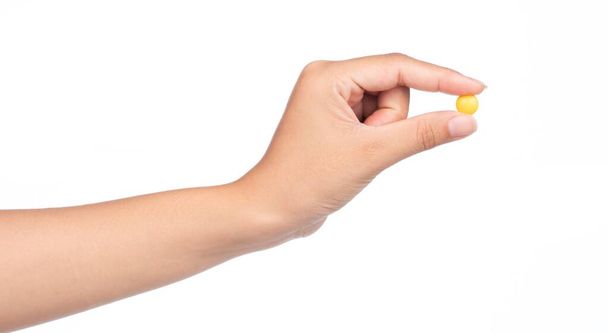 hand holding yellowl chocolate coated candy isolated on white background - Photo, Image