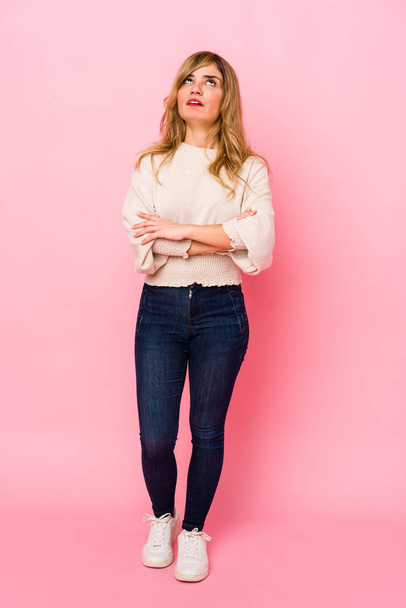 Young blonde caucasian woman standing over a pink background tired of a repetitive task. - Foto, Imagen