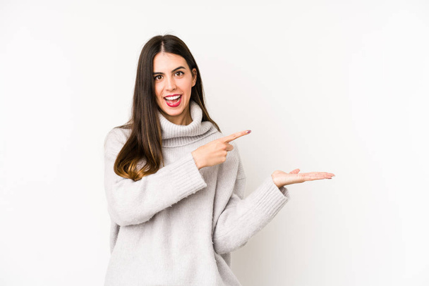 Young caucasian woman isolated on a white background excited holding a copy space on palm. - Photo, Image