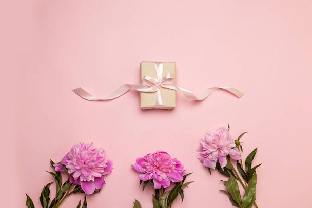 Romantikus nyaralás kompozíció ajándék doboz selyem szalaggal és rózsaszín peone. Anyák napja koncepció - Fotó, kép