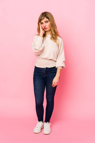 Young blonde caucasian woman standing over a pink background who is bored, fatigued and need a relax day. - Foto, Imagem