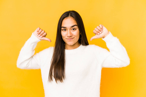 Young woman isolated on a yellow background feels proud and self confident, example to follow. - Photo, Image