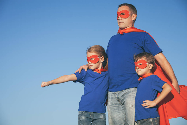 Father and children playing superhero at the day time. People having fun outdoors. Concept of friendly family. - Foto, Imagem