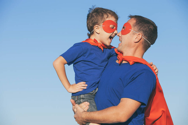 Father and son playing superhero at the day time. People having fun outdoors. Concept of friendly family. - Foto, immagini