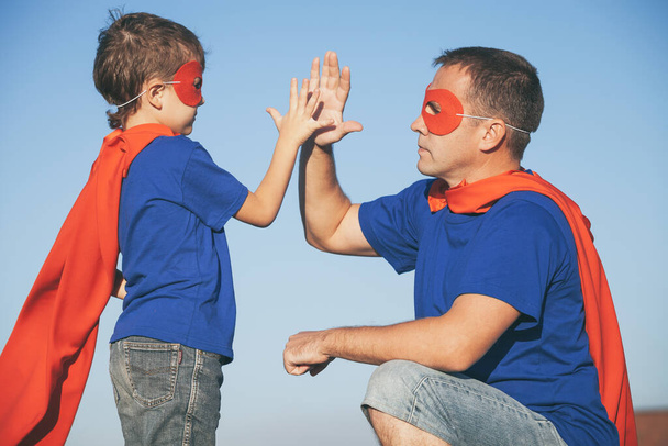 Father and son playing superhero at the day time. People having fun outdoors. Concept of friendly family. - Foto, Bild