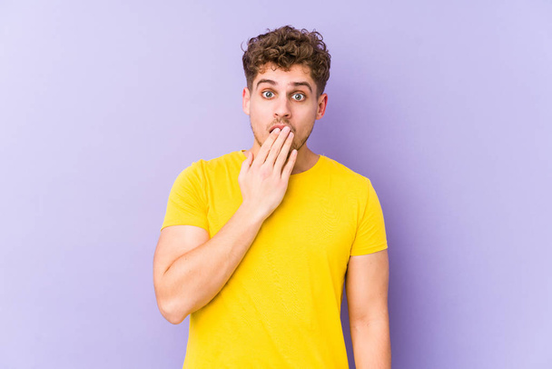 Jovem loiro cabelo encaracolado caucasiano homem isolado bocejo mostrando um gesto cansado cobrindo a boca com a mão. - Foto, Imagem