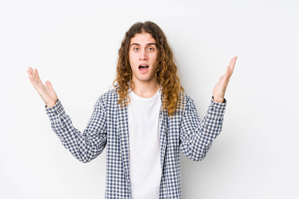 Young long hair man posing isolated receiving a pleasant surprise, excited and raising hands. - Photo, Image
