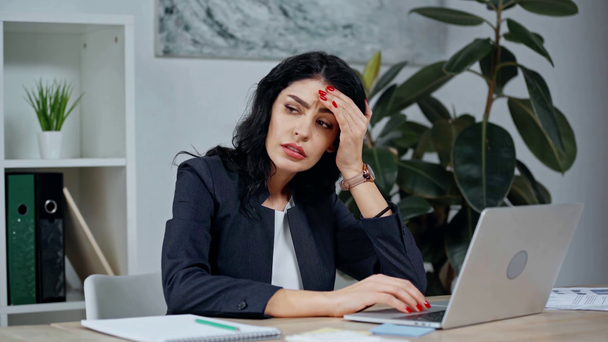 Müde Geschäftsfrau leidet unter Kopfschmerzen beim Tippen auf Laptop - Filmmaterial, Video