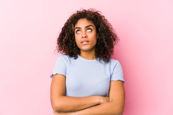 Young african american woman against a pink background tired of a repetitive task. - Foto, imagen