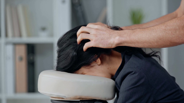 vista parziale del massaggiatore che fa massaggio alla testa alla donna d'affari sulla sedia da massaggio
 - Filmati, video