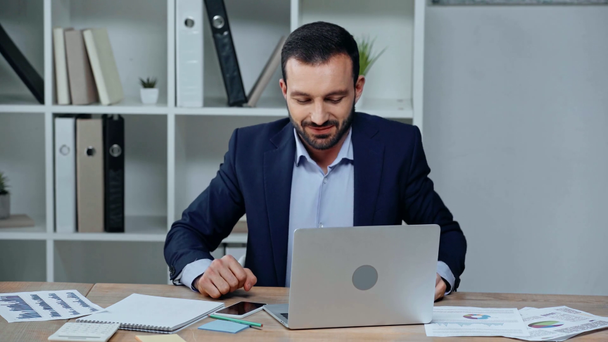 schöner Geschäftsmann tippt auf Laptop und berührt schmerzhaften Hals - Filmmaterial, Video