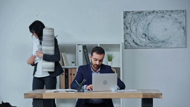 empresária tomando tapete de fitness e toalha enquanto colega sentado no local de trabalho
 - Filmagem, Vídeo