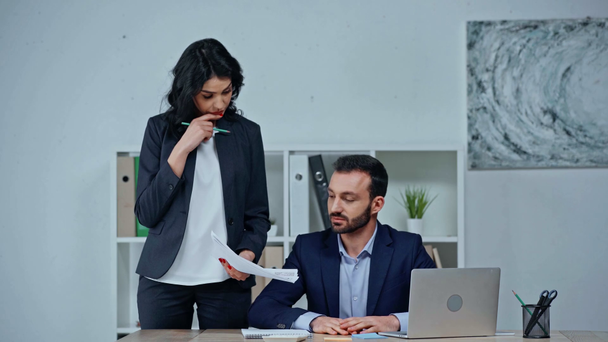empresária mostrando documentos para colega sentado no local de trabalho
 - Filmagem, Vídeo
