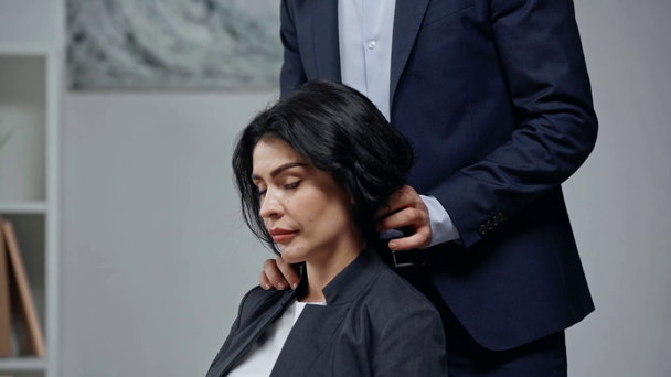 cropped view of businessman making shoulders massage to attractive colleague - Filmagem, Vídeo