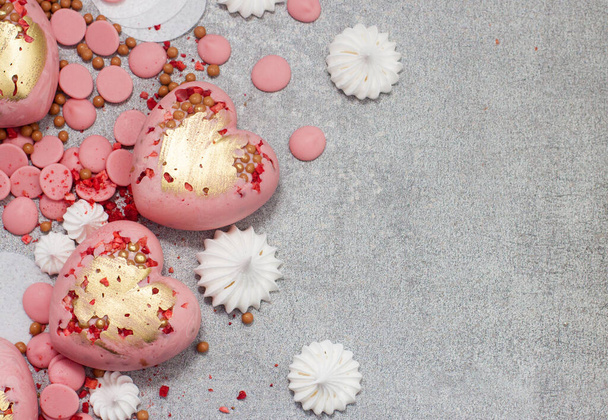 Cuori rosa di cioccolato temperato con gocce di cioccolato, meringhe e bacche secche
 - Foto, immagini
