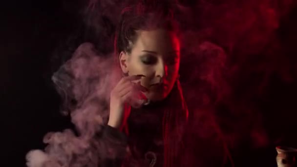 Aantrekkelijk meisje met vlechten aanraken gezicht in rook - Video