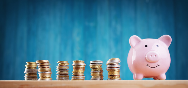 piggy bank with stacked coins on blue background - Photo, Image
