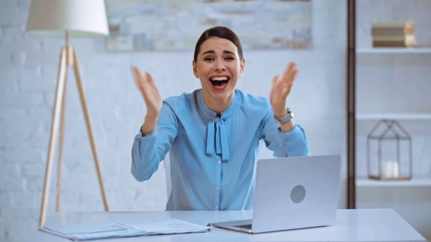збуджена бізнес-леді, що друкує на ноутбуці та жестикулює в офісі
  - Кадри, відео
