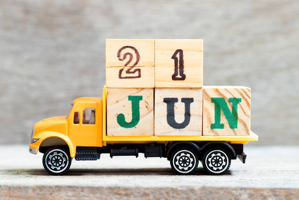 Truck hold letter block in word 21jun on wood background (Concept for date 21 month June) - Photo, Image
