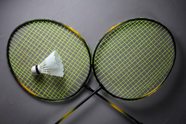 twee rackets en een shuttlecock voor het spelen van badminton op een betonnen achtergrond - Foto, afbeelding