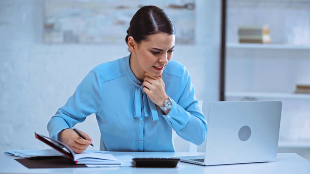 Dizüstü bilgisayar kullanan ve not defterine yazan stresli iş kadını  - Video, Çekim