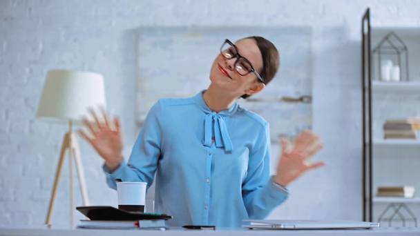 szczęśliwy businesswoman gestykulacji i picia kawy  - Materiał filmowy, wideo