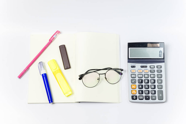 Set of Stationery office equipment or study as Glasses, pen, liquid, marker and calculator on notebook with blank center position on white background. Back to school concept. Work concept. - Fotografie, Obrázek