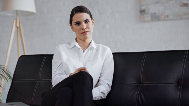 Geschäftsfrau gestikuliert und redet auf Sofa - Filmmaterial, Video
