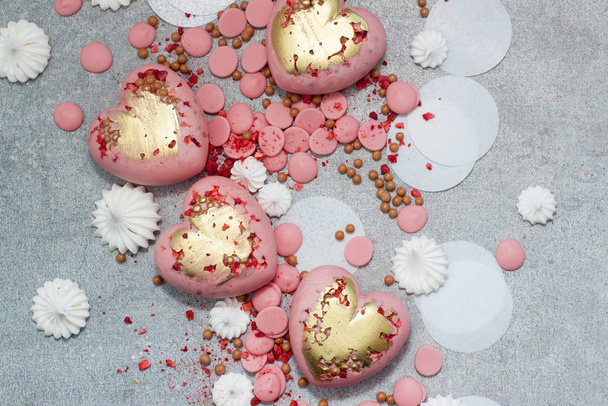 Pink hearts from tempered chocolate with chocolate drops, meringues and dried berries - Fotó, kép