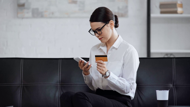 деловая женщина в очках с кредитной картой и смартфоном
 - Кадры, видео