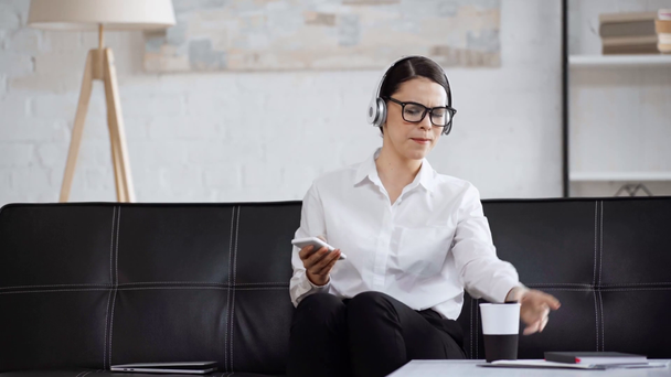 donna d'affari in occhiali con computer portatile e musica d'ascolto
  - Filmati, video
