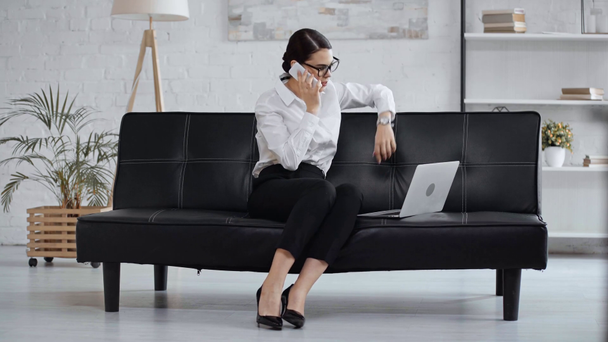 mujer de negocios hablando en el teléfono inteligente y utilizando el ordenador portátil
  - Metraje, vídeo