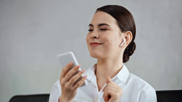 щаслива бізнес-леді слухає музику в бездротових навушниках
 - Кадри, відео