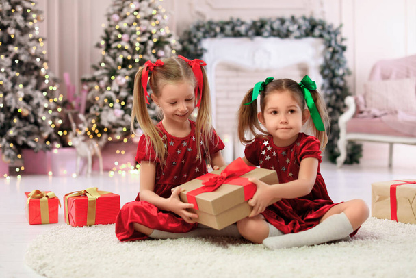 Cute little children with Christmas gifts at home - Photo, Image