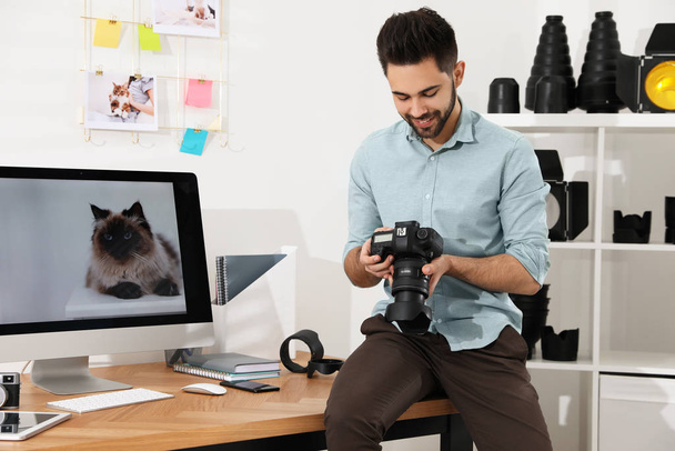 Professional photographer with camera working in light modern office - Фото, зображення