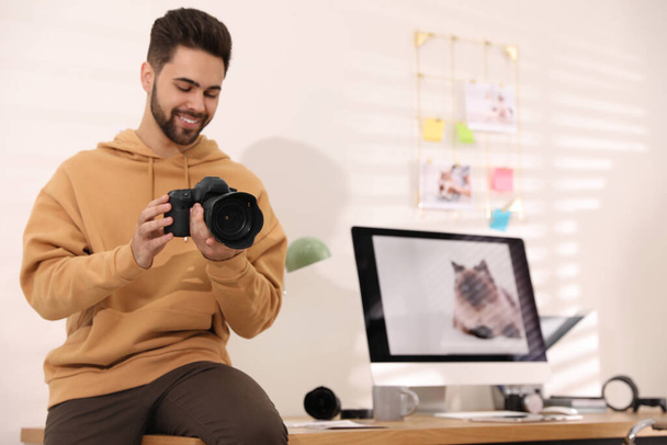 Professional photographer with camera working in light modern office - Foto, Bild