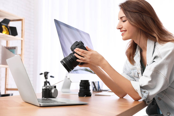 Professional photographer with camera working at table in office - 写真・画像