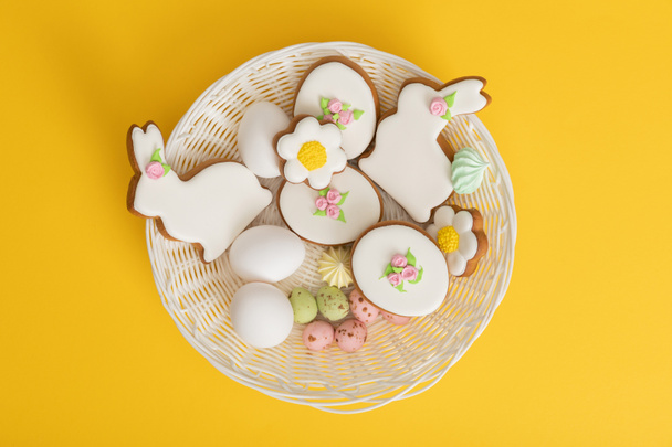 Top view of bowl with delicious easter cookies on yellow background - Фото, зображення