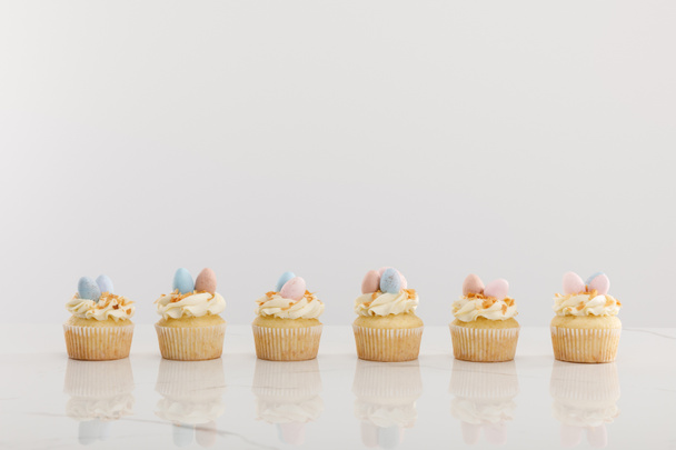 Delicious easter cupcakes isolated on grey - 写真・画像