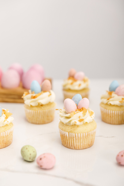 Selective focus of delicious easter cupcakes with painted quail eggs on grey background - Photo, Image