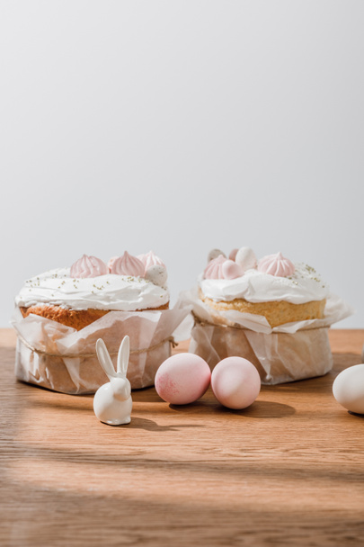 Dekoratif tavşanlar, tavuk yumurtaları ve gri üzerine izole edilmiş Paskalya ekmeği. - Fotoğraf, Görsel