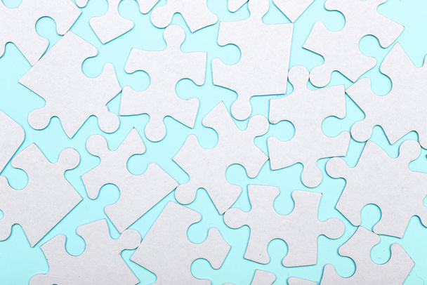 Кусочки головоломки соединены на синем фоне со многими другими частями головоломки. Концепция совместной работы
. - Фото, изображение